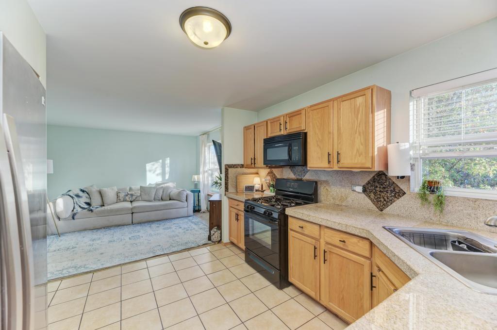 3608 Fiday Road Joliet, IL 60431 - Photo 8 of 27 a kitchen with stainless steel appliances granite countertop a sink dishwasher stove and white cabinets with wooden floor