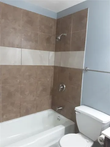 a bathroom with a toilet and bathtub