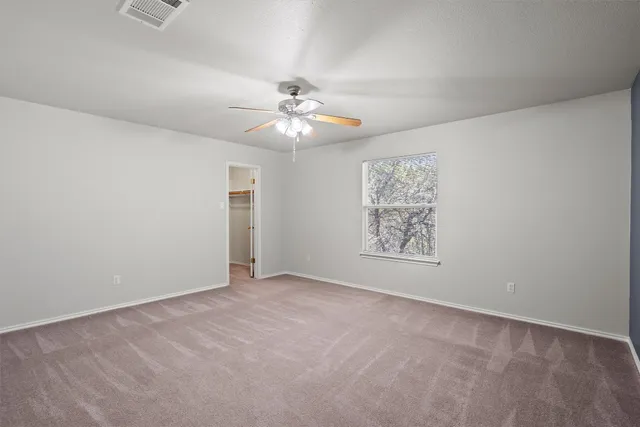 an empty room with fan and windows