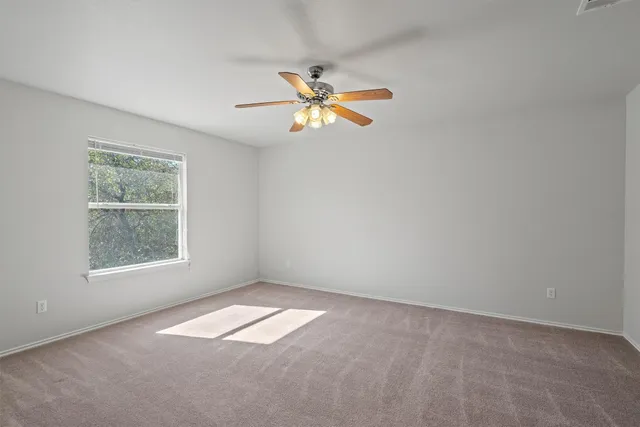 an empty room with a window and a fan