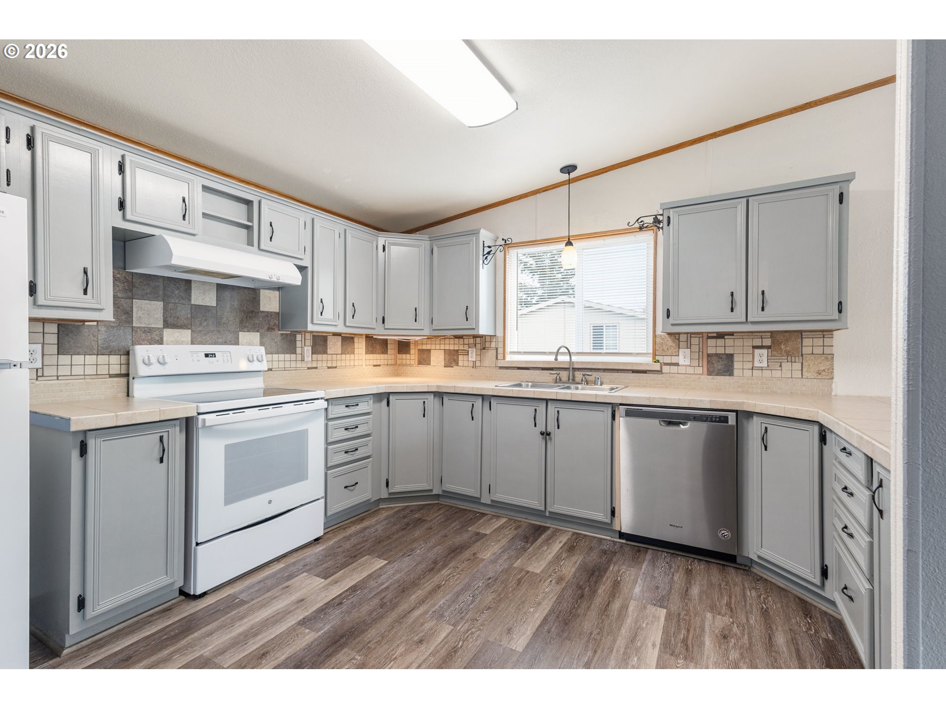 336 Franklin Place Longview, WA 98632 - Photo 8 of 28 a kitchen with stainless steel appliances granite countertop a stove a sink dishwasher and white cabinets with wooden floor