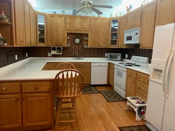 a kitchen with a sink a stove cabinets and wooden floor