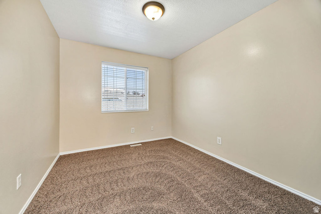 2 West 1780 North Logan, UT 84341 - Photo 11 of 24 Carpeted empty room featuring baseboards and a textured ceiling