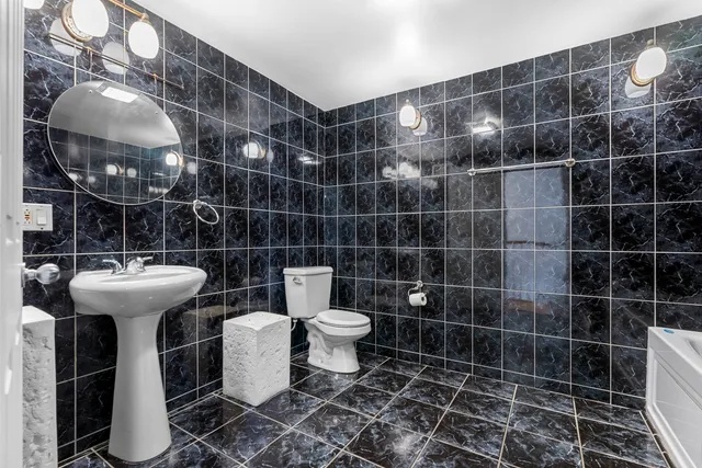 a bathroom with a sink toilet and a mirror