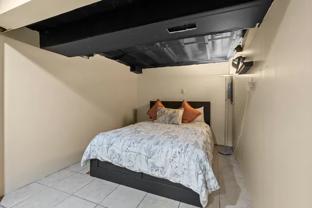 a bed sitting in a bedroom next to a window