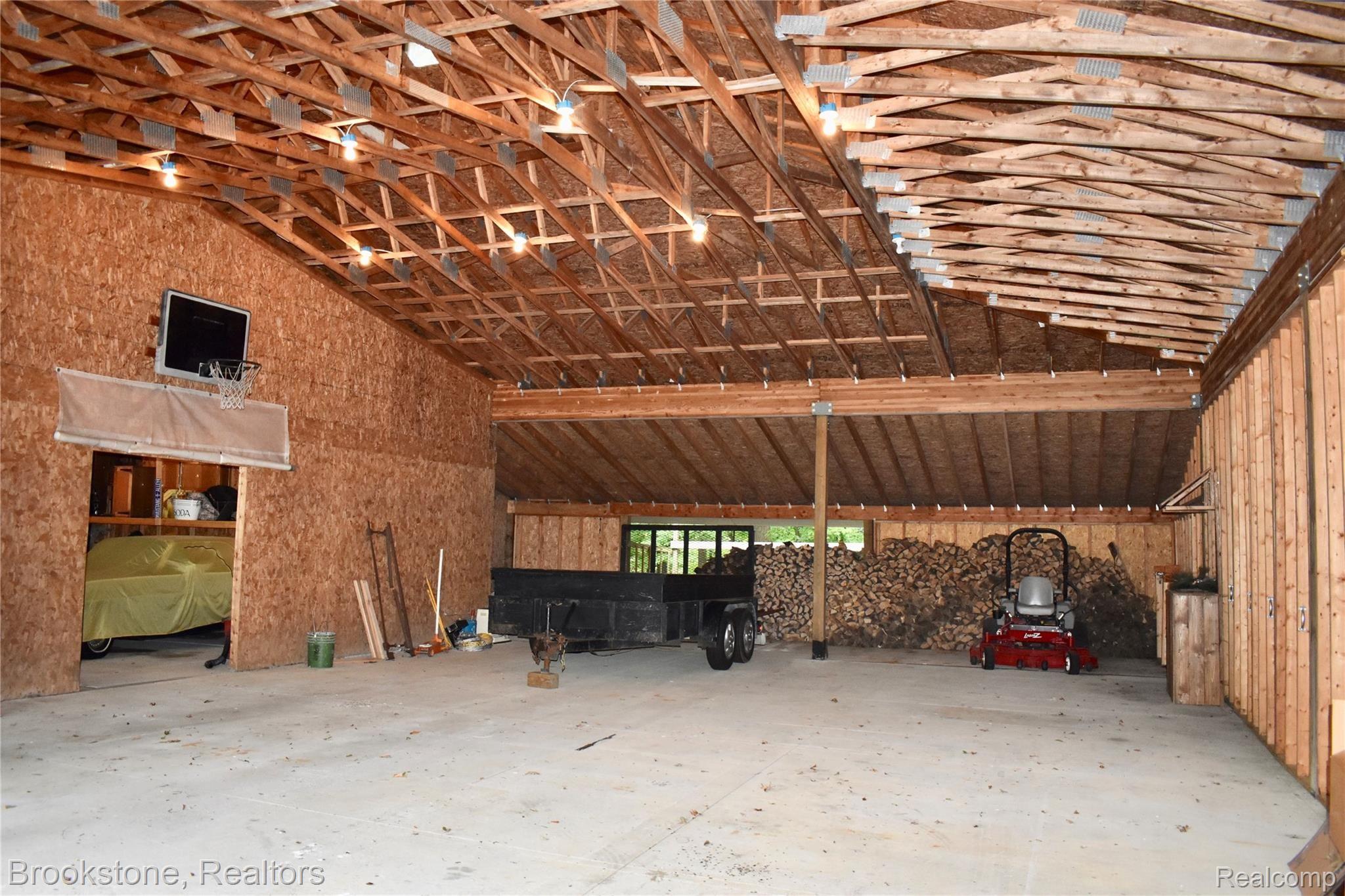 405 Baldwin Ridge Oxford, MI 48371 - Photo 6 of 54 THE LARGE PAVILION (36X52) WAS DESIGNED TO STORE OUR CAMPER, PLAY INDOOR BASKETBALL & FOR ENTERTAINING (SUCH AS GRAD, BIRTHDAY, WEDDING, ANNIVERSARY, SHOWER & HALLOWEEN PARTIES). THE SIDES OF THE PAVILION ARE REMOVABLE WHICH ALLOW FOR A WONDERFUL OPEN AREA IN THE SUMMER. IT CAN EASILY SEAT & SERVE MORE THAN 100 PEOPLE! THE DOORWAY TO THE LEFT LEADS TO THE 8 CAR HEATED GARAGE
