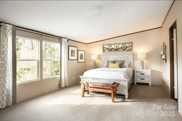 a bedroom with a bed and a large window
