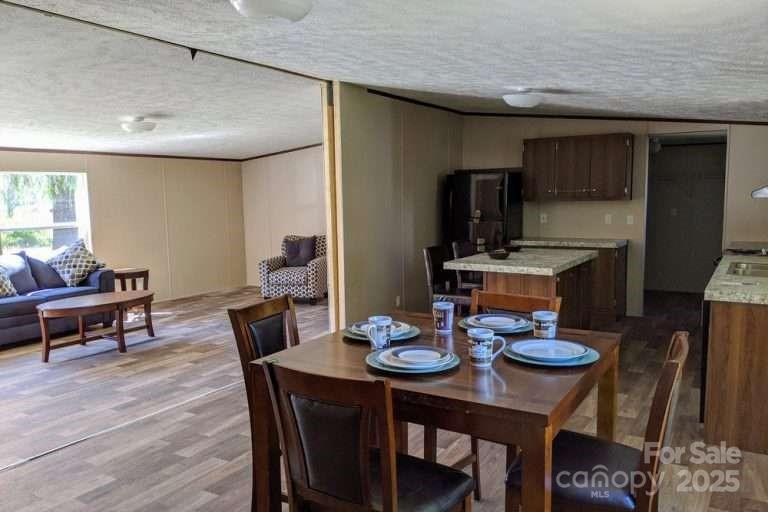 2294 Old Georgetown Road West, Unit 2 Cassatt, SC 29032 - Photo 8 of 12 a view of a dining room and kitchen with furniture wooden floor and a chandelier