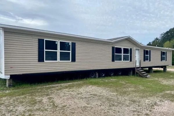 a kitchen with stainless steel appliances granite countertop a stove top oven a refrigerator a sink and dishwasher with wooden floor