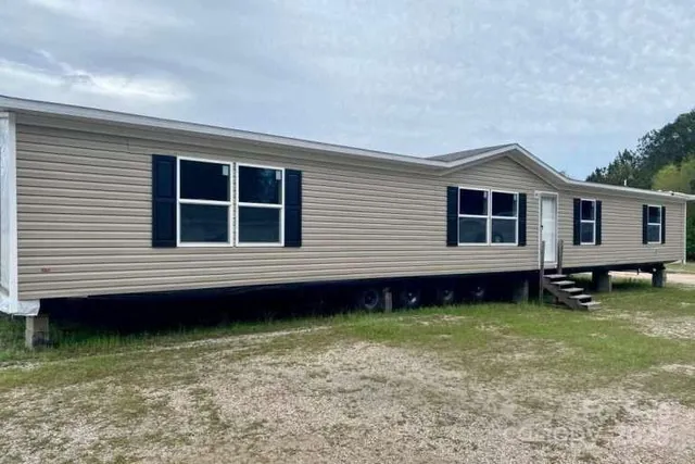 a kitchen with stainless steel appliances granite countertop a stove top oven a refrigerator a sink and dishwasher with wooden floor