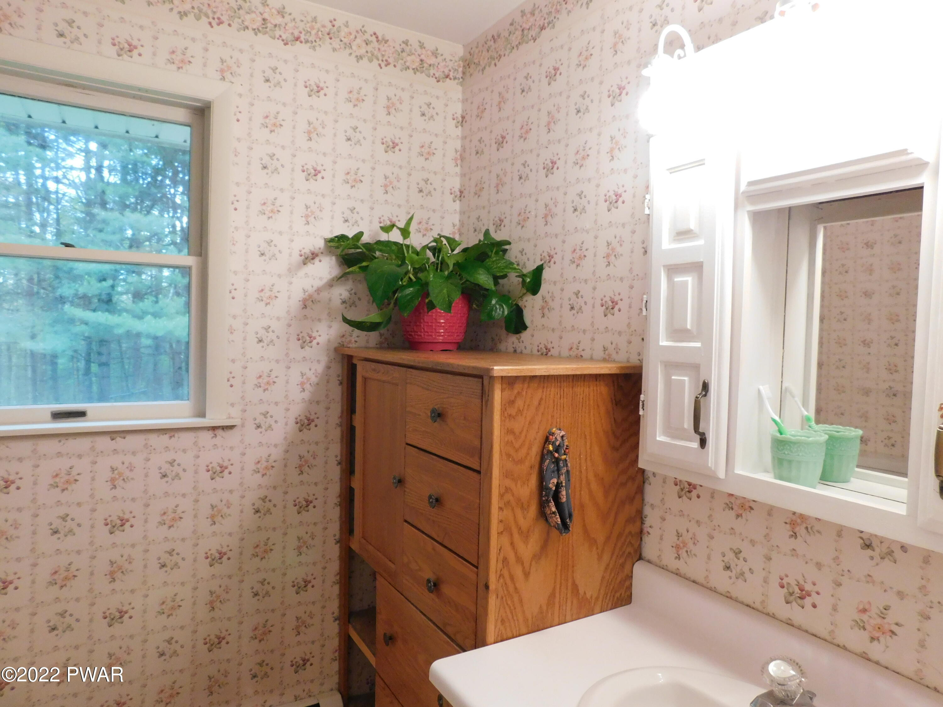 191 Fox Road Dingmans Ferry, PA 18328 - Photo 23 of 27 a bathroom with a sink a mirror and a toilet
