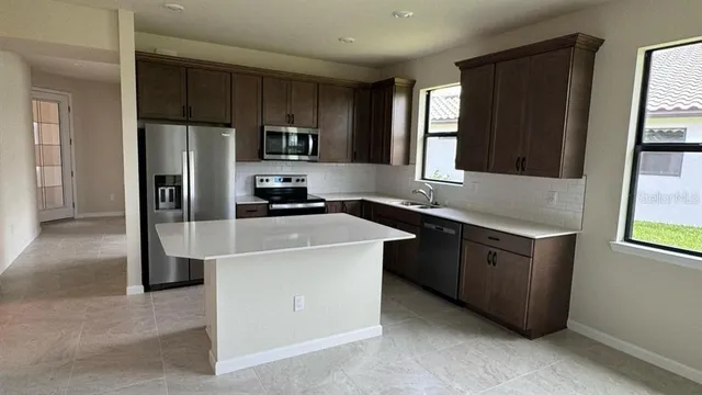 a kitchen with stainless steel appliances a refrigerator sink and cabinets