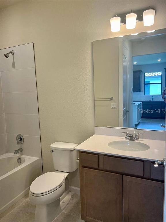 4139 Silver Maple Way Vero Beach, FL 32967 - Photo 7 of 29 a bathroom with a sink a toilet a mirror a vanity and bathtub