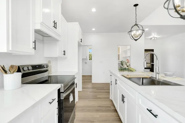 a kitchen with stainless steel appliances granite countertop a sink a stove and a refrigerator