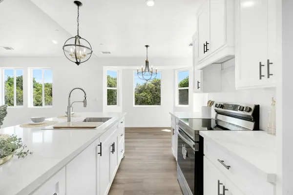 a kitchen with stainless steel appliances granite countertop a stove a sink and a window
