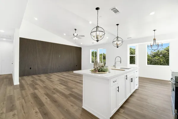 a kitchen with stainless steel appliances kitchen island granite countertop a sink a stove a dining table and chairs
