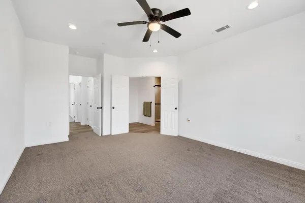 a view of a big room with closet and ceiling fan