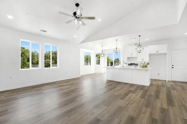 a view of an empty room with window and wooden floor