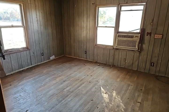 644 16th Street Colorado City, TX 79512 - Photo 4 of 12 an empty room with wooden floor and windows