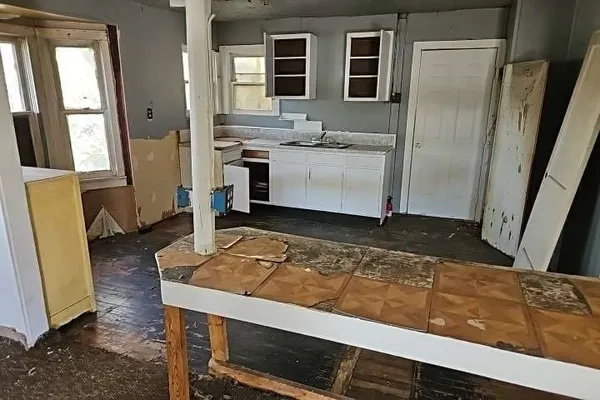 a living room with stainless steel appliances furniture stove and a refrigerator