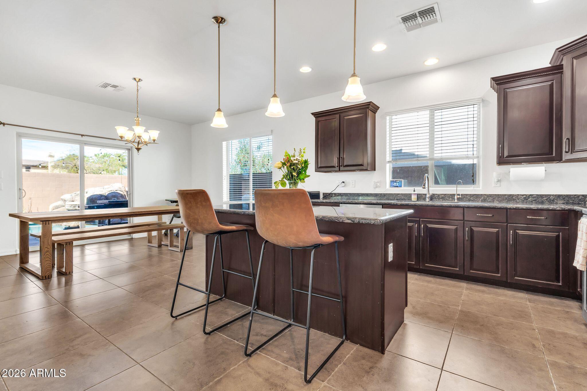 4120 South Butte Lane Gilbert, AZ 85297 - Photo 12 of 29 a kitchen with stainless steel appliances granite countertop a stove a sink a oven a dining table and chairs