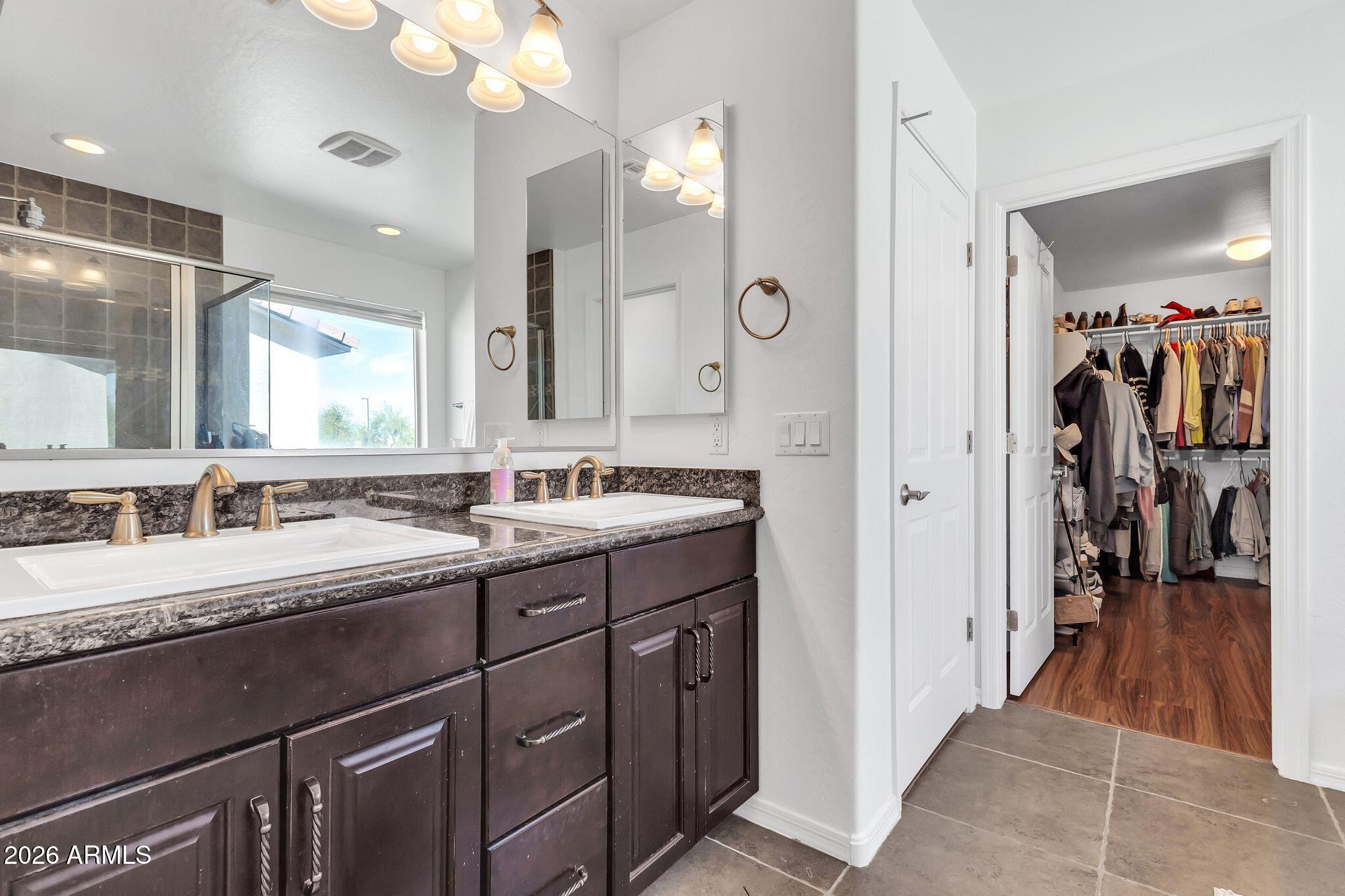 4120 South Butte Lane Gilbert, AZ 85297 - Photo 17 of 29 a bathroom with a double vanity sink and a mirror
