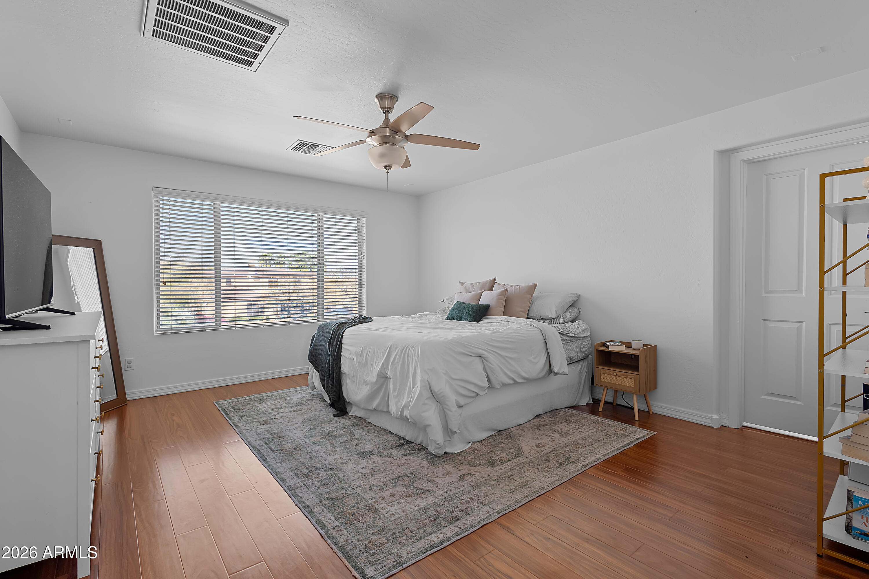 4120 South Butte Lane Gilbert, AZ 85297 - Photo 18 of 29 a bedroom with a bed and wooden floor