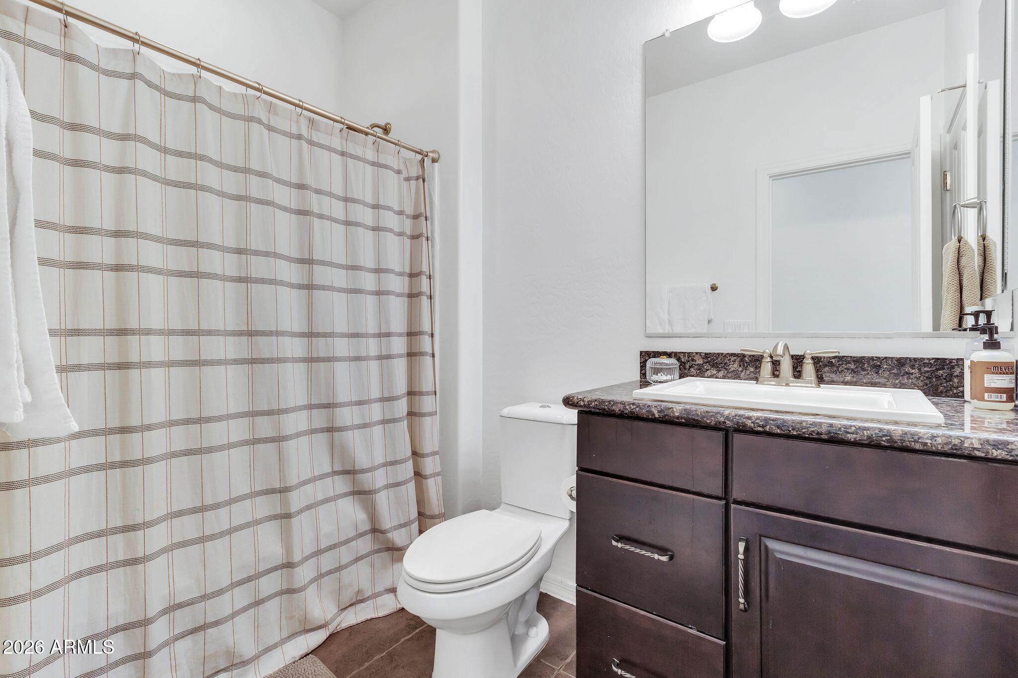 4120 South Butte Lane Gilbert, AZ 85297 - Photo 21 of 29 a bathroom with a granite countertop sink toilet and shower