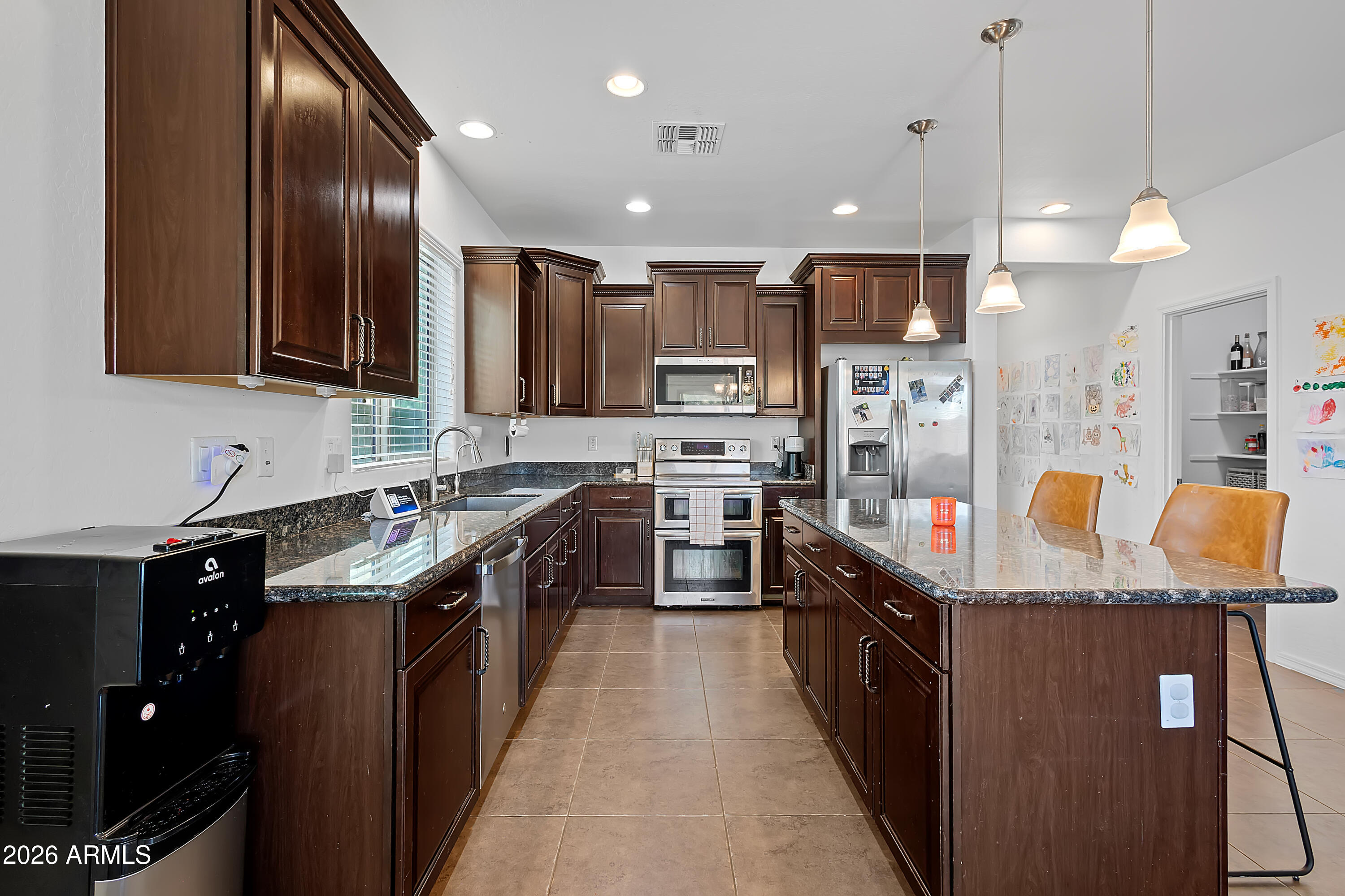 4120 South Butte Lane Gilbert, AZ 85297 - Photo 10 of 29 a kitchen with stainless steel appliances granite countertop counter space a sink and a refrigerator