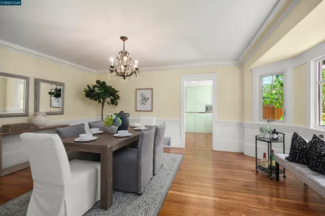 a dining room with furniture a chandelier and wooden floor