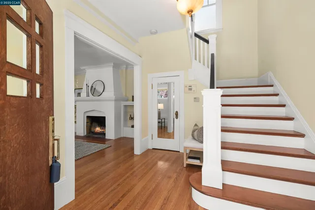 a view of a livingroom with wooden floor and a fireplace