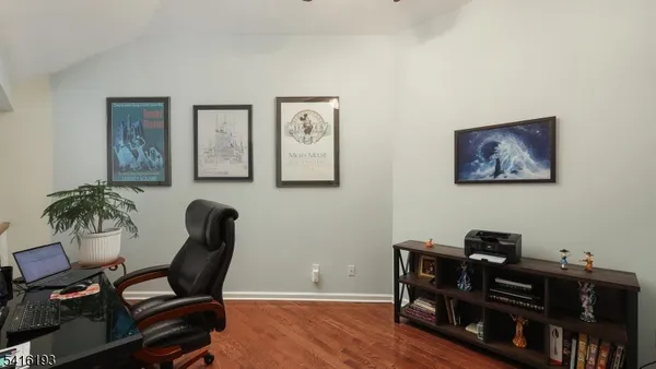 a view of a workspace with furniture and wooden floor