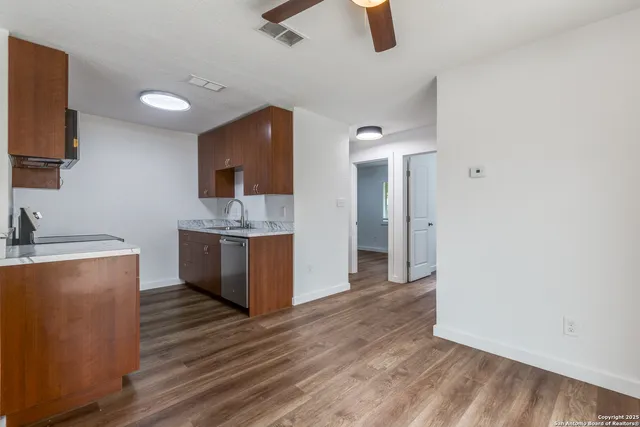 a large kitchen with a lot of counter space and wooden floor