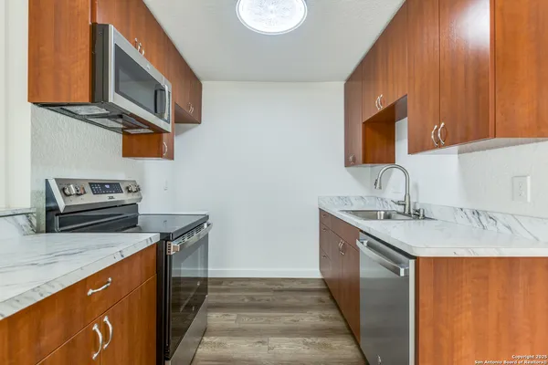 a kitchen with stainless steel appliances granite countertop a sink stove and cabinets