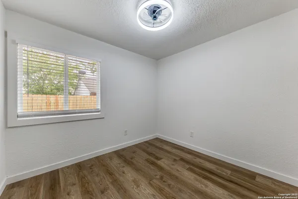 a view of a room that has wooden floor and a window