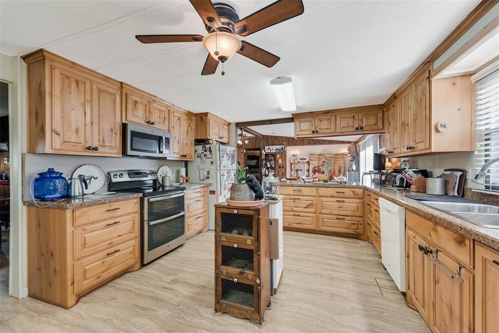 510 North D Ranch Road Waxahachie, TX 75167 - Photo 14 of 38 a kitchen with stainless steel appliances granite countertop lots of counter top space wooden cabinets and a window