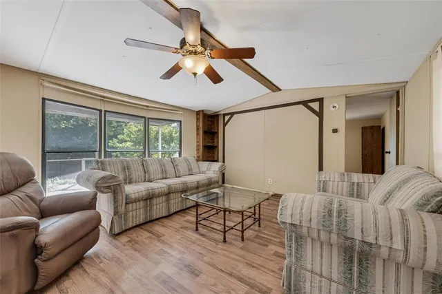 a living room with furniture kitchen view and a chandelier