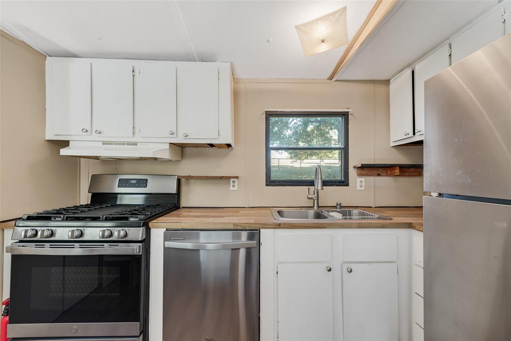510 North D Ranch Road Waxahachie, TX 75167 - Photo 26 of 38 a kitchen with stainless steel appliances granite countertop a sink stove and refrigerator