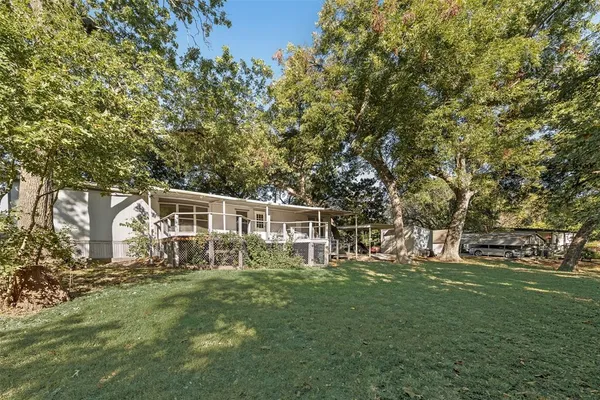 a view of yard from deck with patio