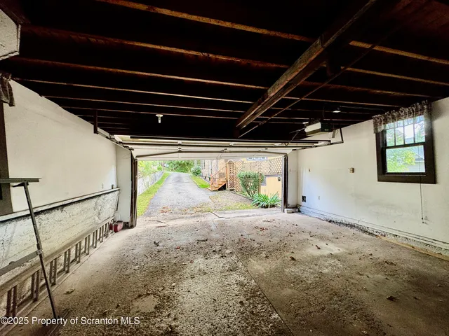 a view of empty room with wooden floor and window