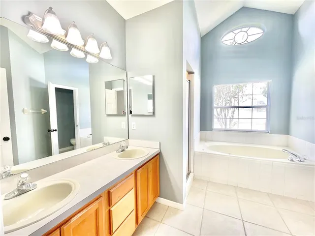 a spacious bathroom with a tub sink and mirror