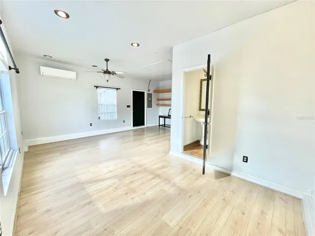 a view of a livingroom with wooden floor and a ceiling fan