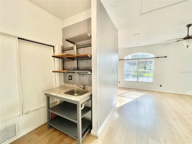 a view of kitchen with sink and refrigerator