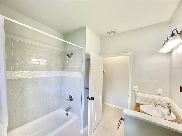 a bathroom with a bathtub shower sink vanity and a toilet