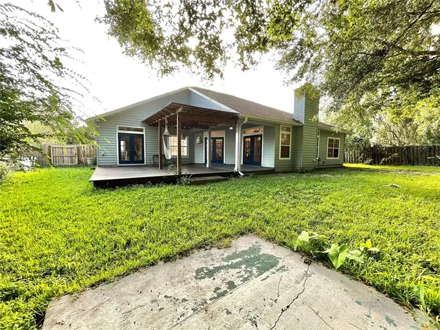 a front view of a house with a garden and trees