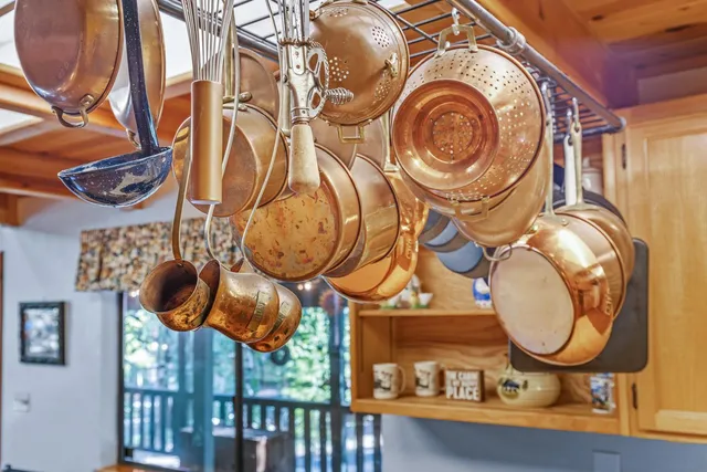 a kitchen with stainless steel appliances kitchen island granite countertop a table chairs in it and wooden floors