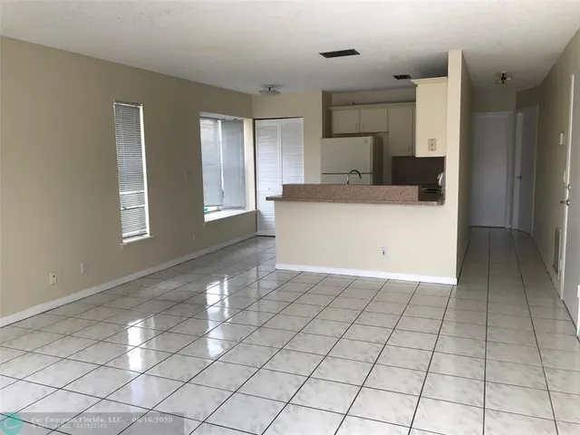 a view of empty room with cabinet and window