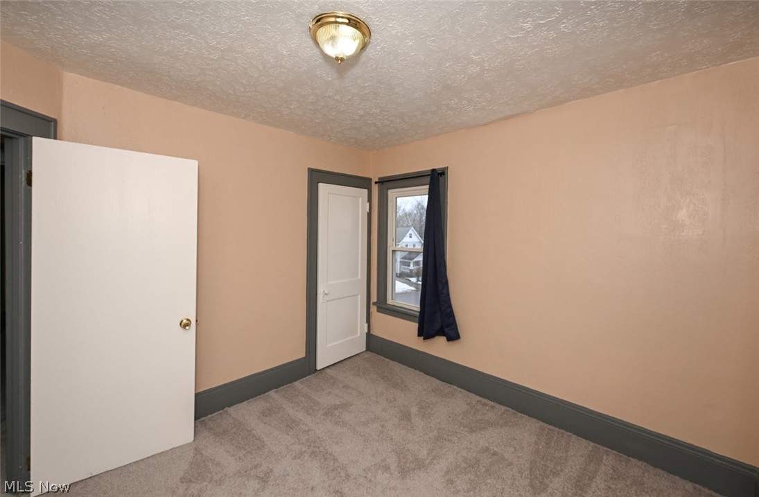 77 West Mildred Avenue Akron, OH 44310 - Photo 23 of 40 Empty room featuring a textured ceiling and light carpet