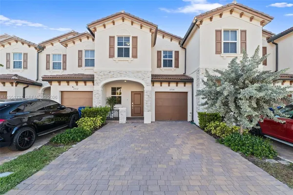 a front view of a house with a yard and garage