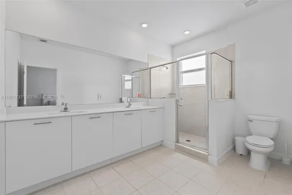 a bathroom with a granite countertop sink a toilet and shower
